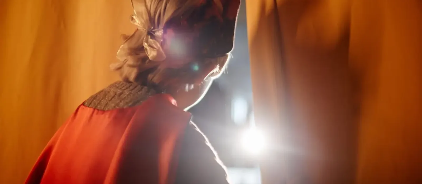 Following Glowing Light Through Curtains in Stage Costume Person wearing a stage costume peeking through the curtains, illuminated by a bright light. Capturing a dramatic moment during a theatrical performance