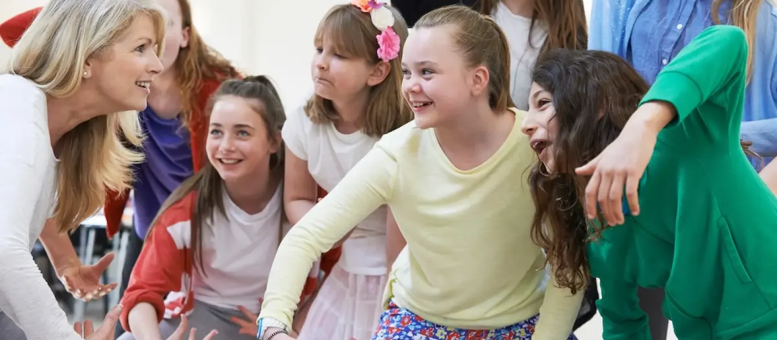 Group Of Children With Teacher Enjoying Drama Class Together Group Of Children With Teacher Enjoying Drama Class Together