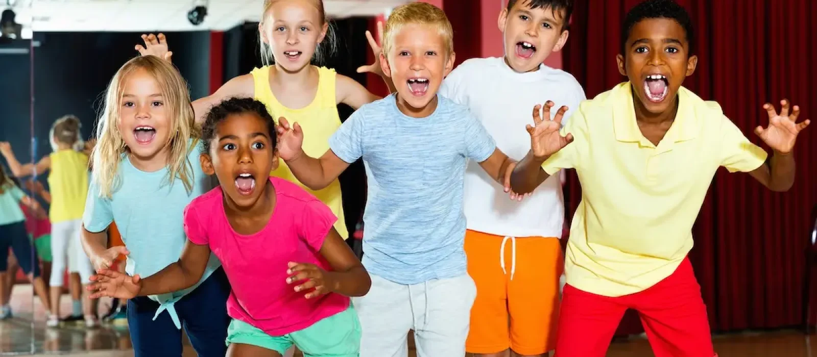 Happy emotional children posing at modern dance class Happy emotional cheerful positive children posing at modern dance class